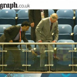 Carlos de Inglaterra espera a que un criado le baje su asiento para sentarse