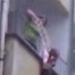 Una mujer baja a una niña por un balcón atada a una cuerda para recuperar una prenda