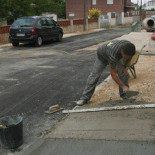 Hartos de esperar, unos vecinos asfaltan su calle