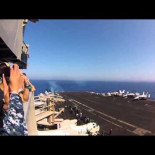 Una pasada supersónica de un F/A-18C junto a un portaaviones