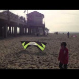 Experto en volar cometas se divierte jugando con un niño en la playa