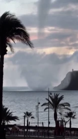 El momento en el que una manga marina toca tierra en Mazarrón provocando daños materiales en el mobiliario urbano