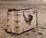 Una mujer mongola asoma por un agujero de la caja en la que fue encerrada (julio 1913)